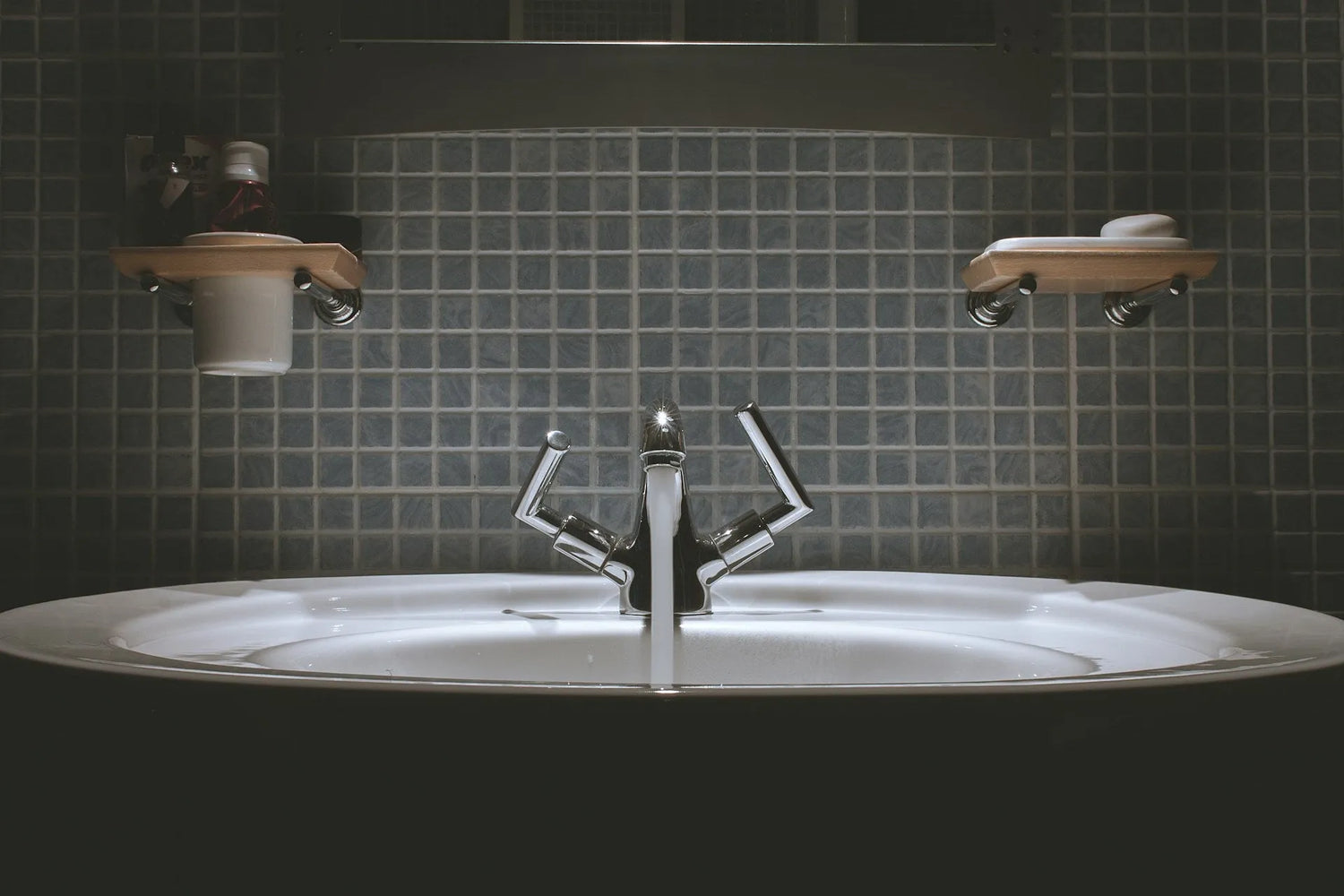 Chrome faucet with clean water flowing into a bathroom sink